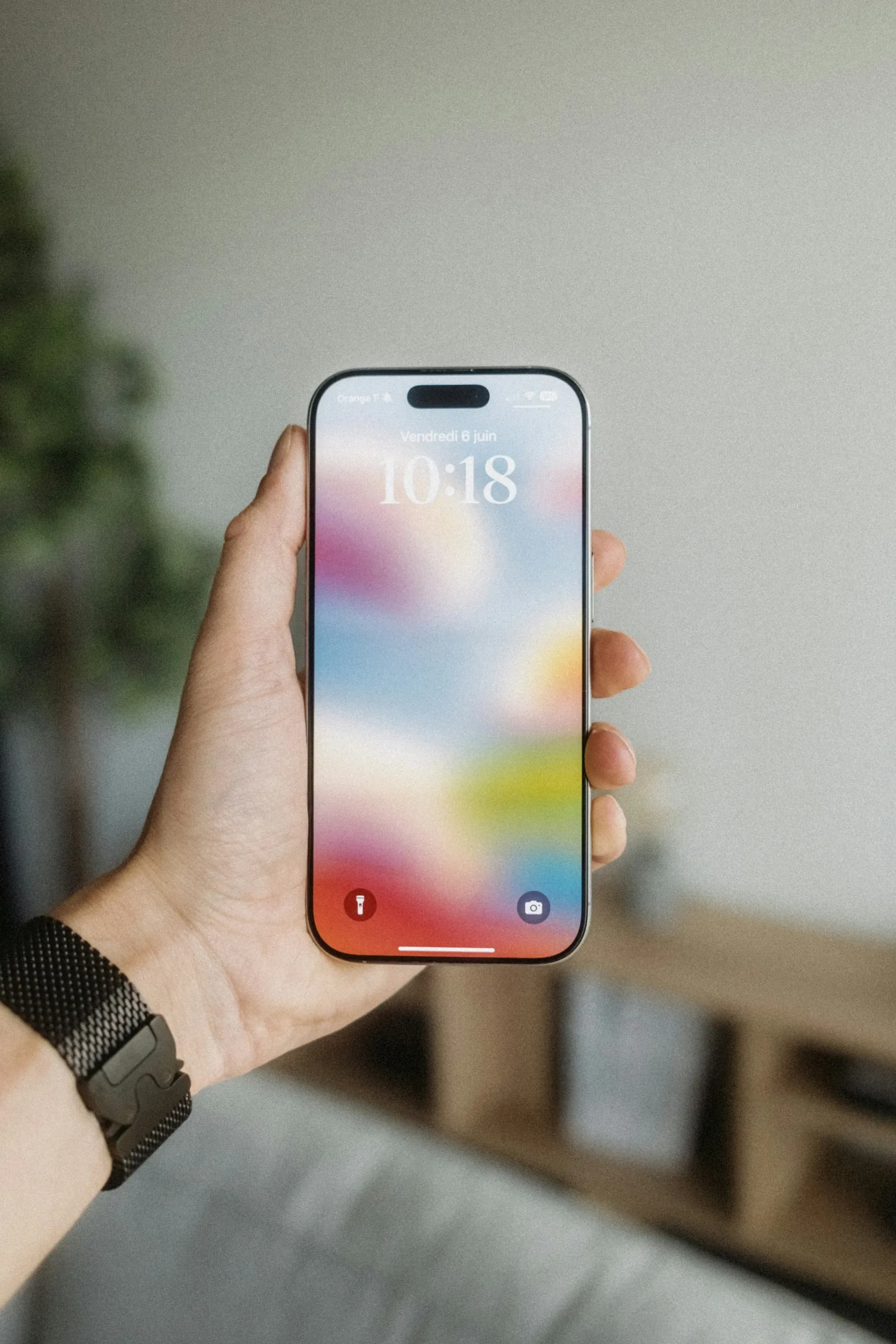 Hand hält ein Smartphone mit farbigem Sperrbildschirm